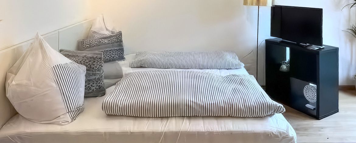 Double bed in the bright living and sleeping area